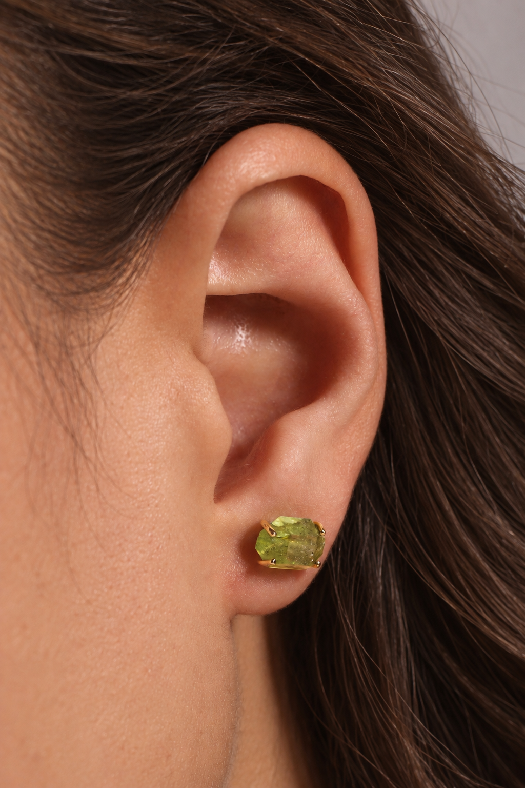 Large Prong Set Herkimer Cut Peridot Stud Earrings Earrings Brunette_Ear_with_Raw_Green_Gemstone